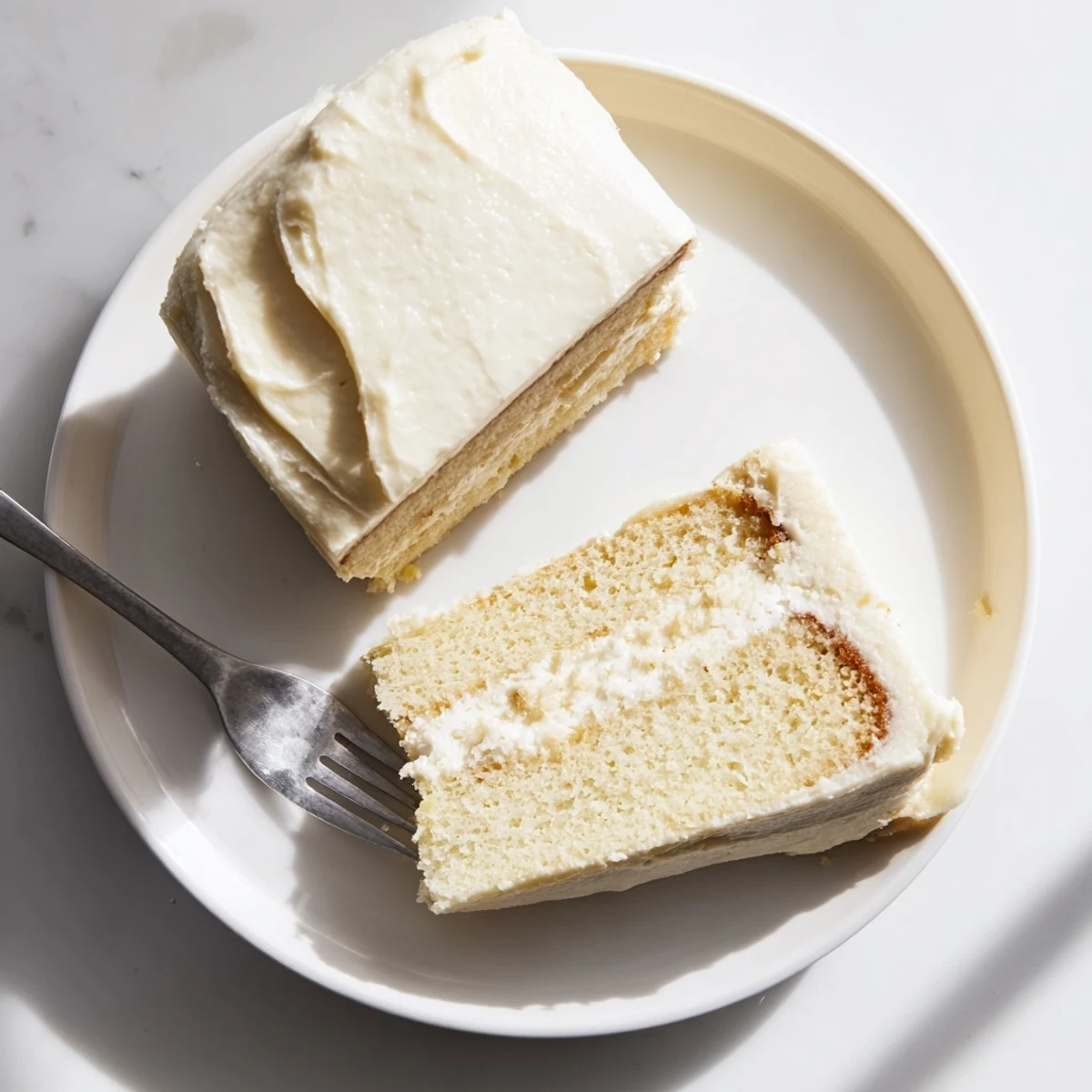 Two-layer perfect vanilla cake topped with smooth white buttercream and decorated with elegant piping for celebrations