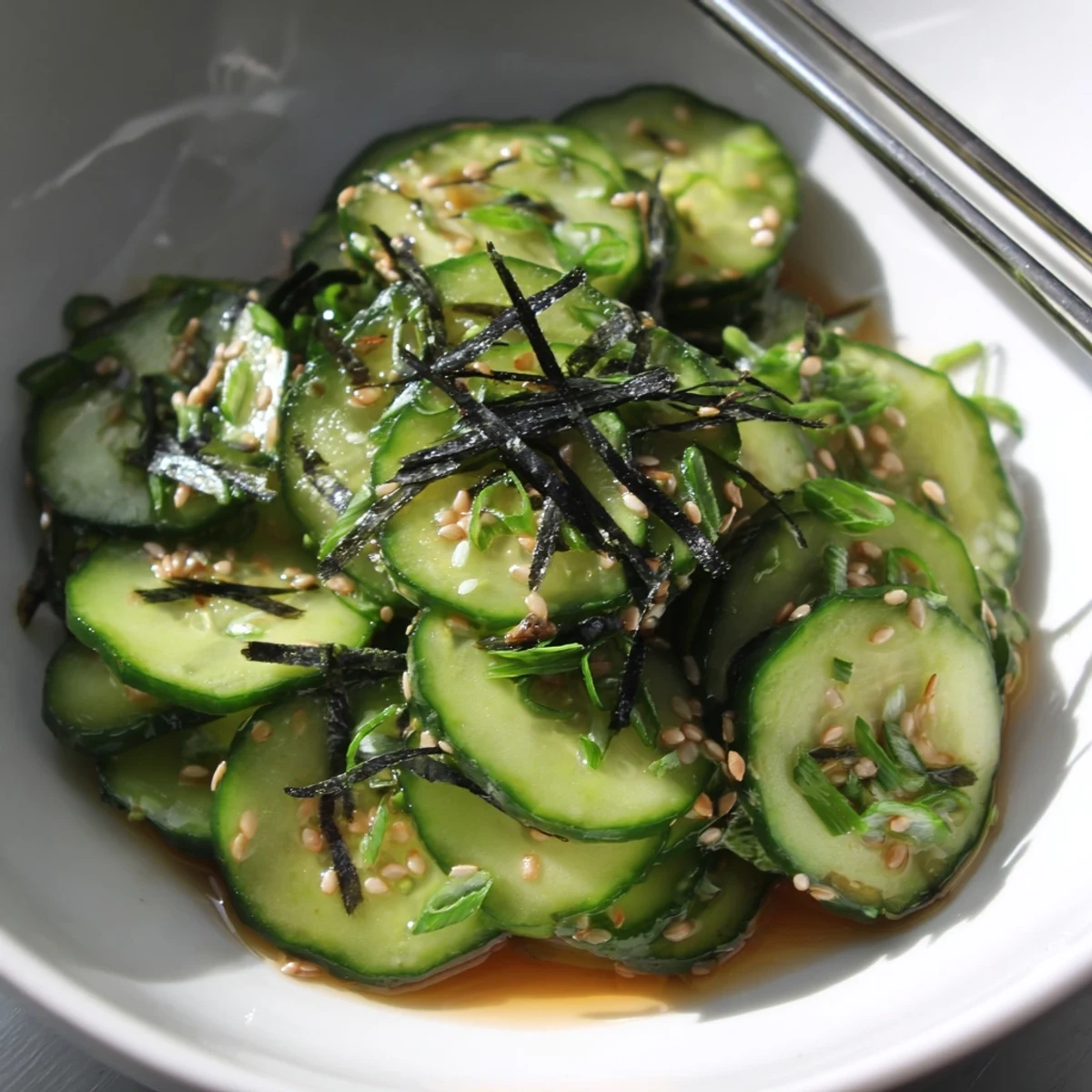Crisp sushi cucumber salad tossed in tangy rice vinegar with toasted sesame seeds and nori strips