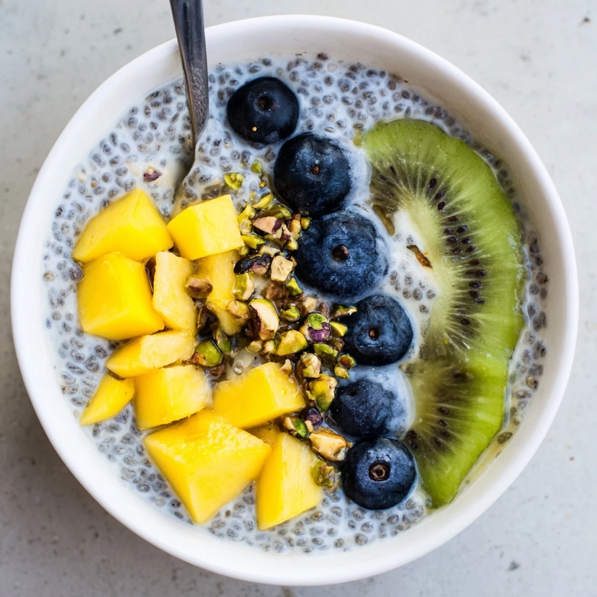 Creamy Coconut Chia Pudding sweetened with maple, garnished with chopped pistachios