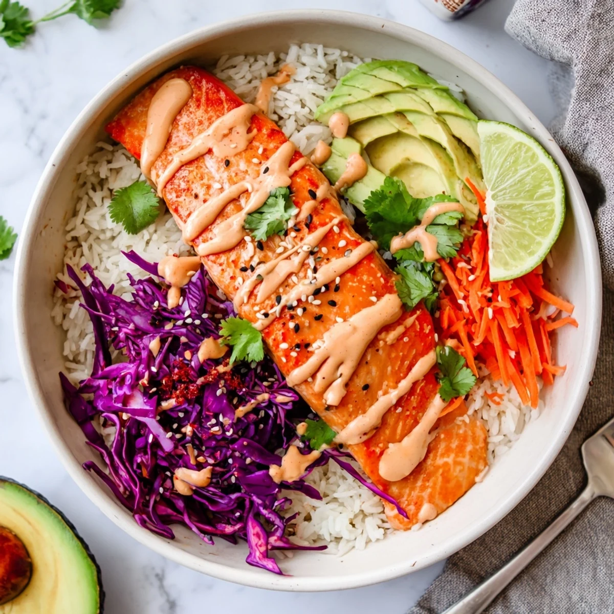Crisp-topped Bang Bang Salmon Bowls Recipe served with sliced avocado, sesame seeds.