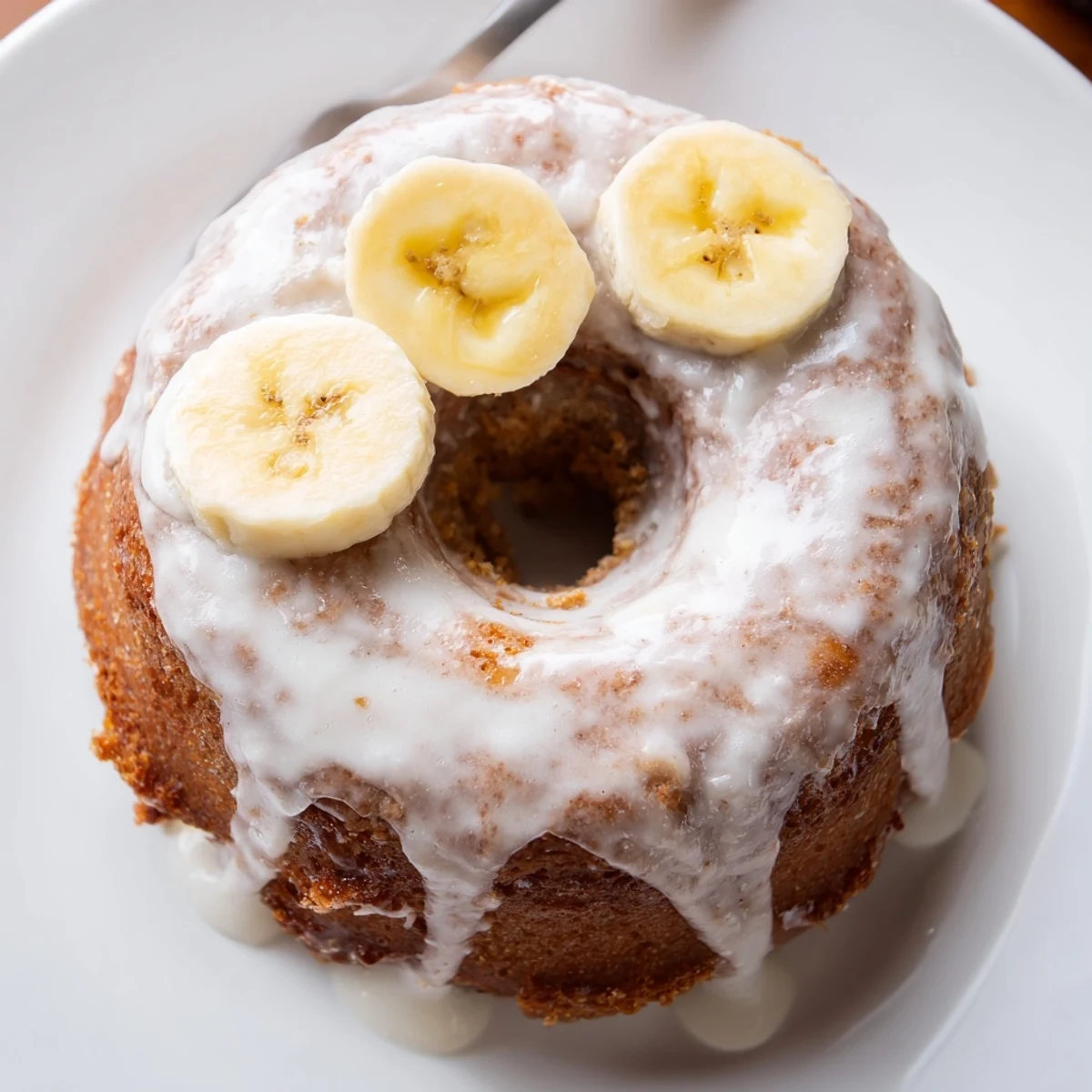 Baked Banana Donuts plated with glaze drizzle and optional chocolate chips