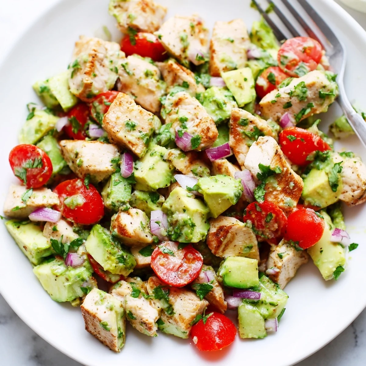 Bright Healthy Avocado Chicken Salad served in bowl, crunchy cucumbers, chopped cilantro