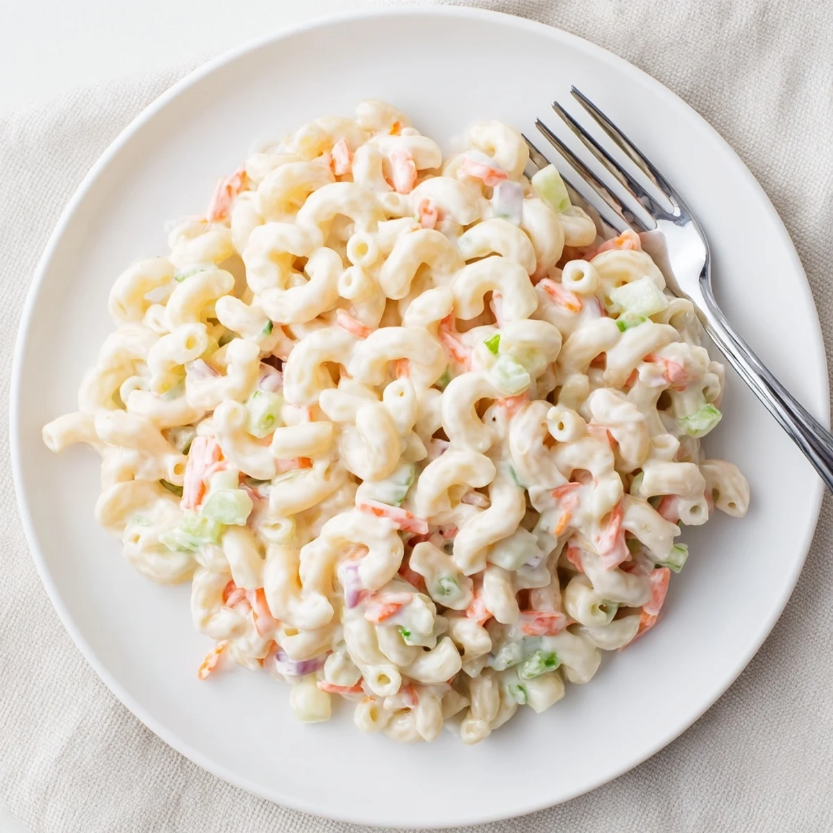 Creamy Hawaiian style mac salad loaded with tender macaroni and crisp colorful vegetables in a large white serving bowl