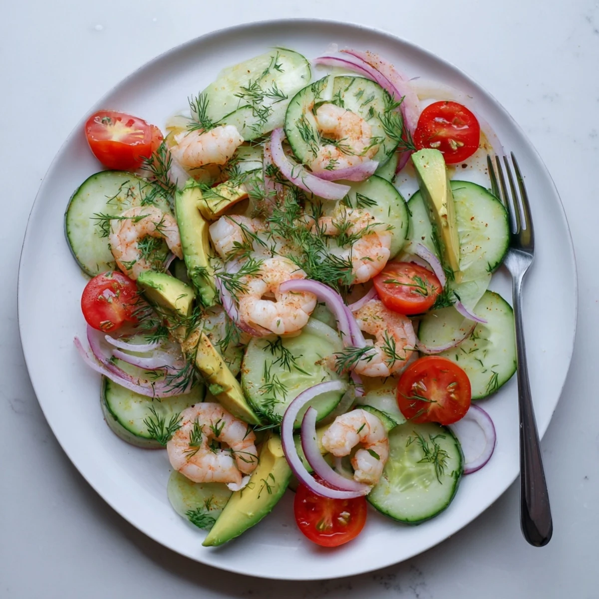 Fresh cucumber shrimp salad featuring plump pink shrimp, crisp sliced cucumbers, ripe avocado, and red onion in a light citrus dressing