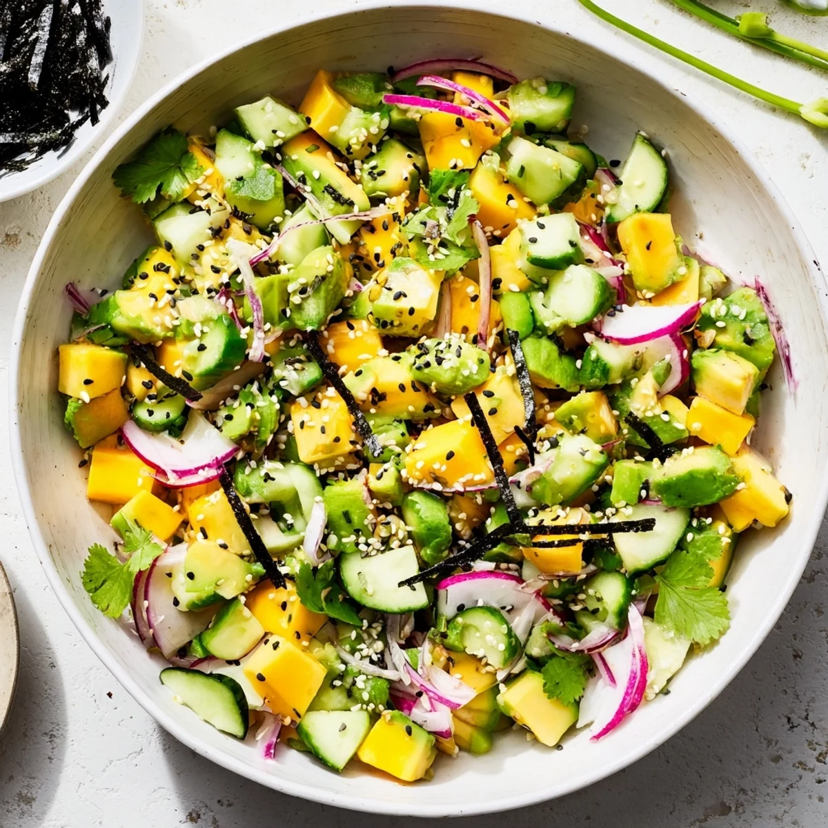 Colorful avocado mango poke salad bowl with fresh diced vegetables and sesame seed garnish