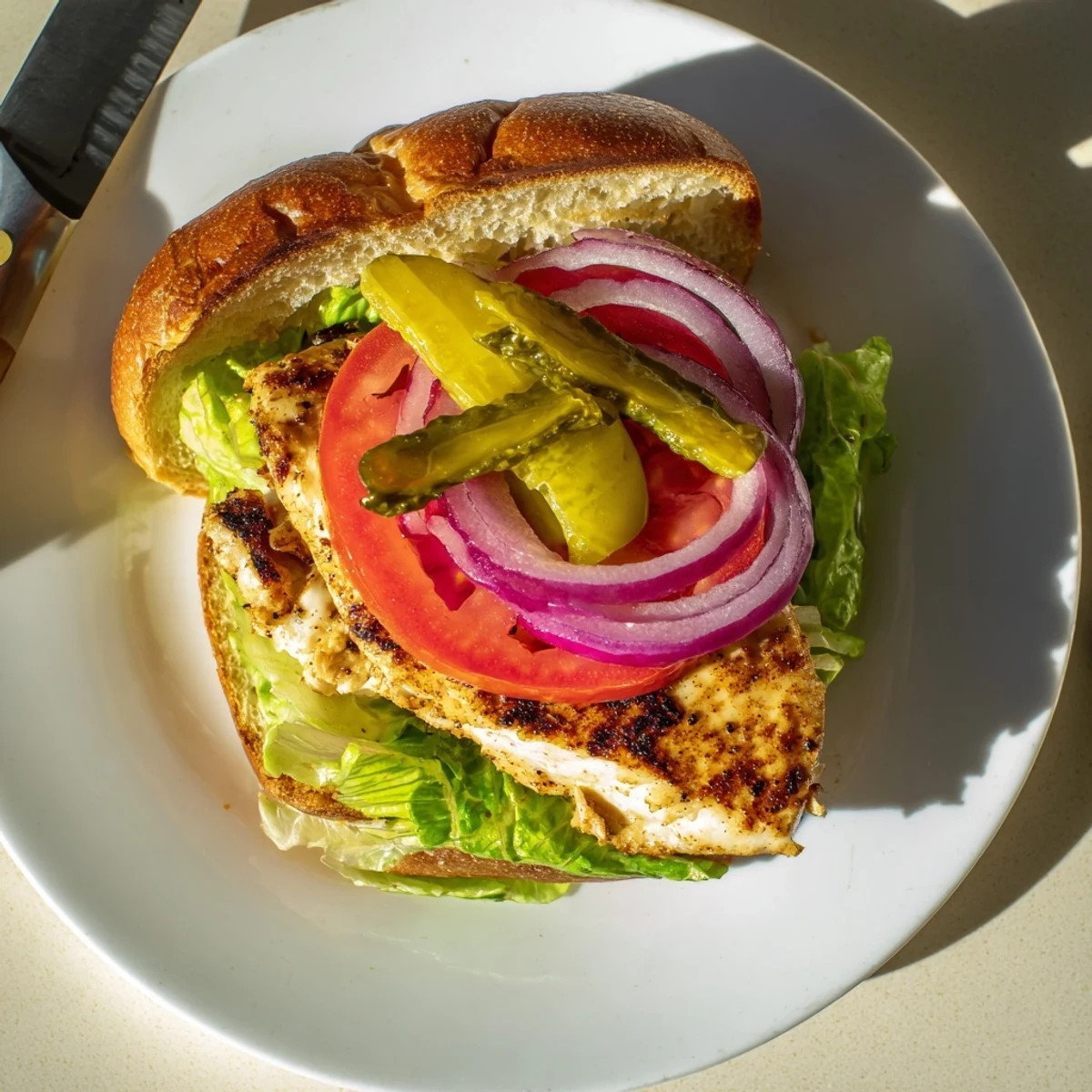 Juicy grilled savory spiced chicken sandwich stacked high with crisp vegetables and creamy sauce