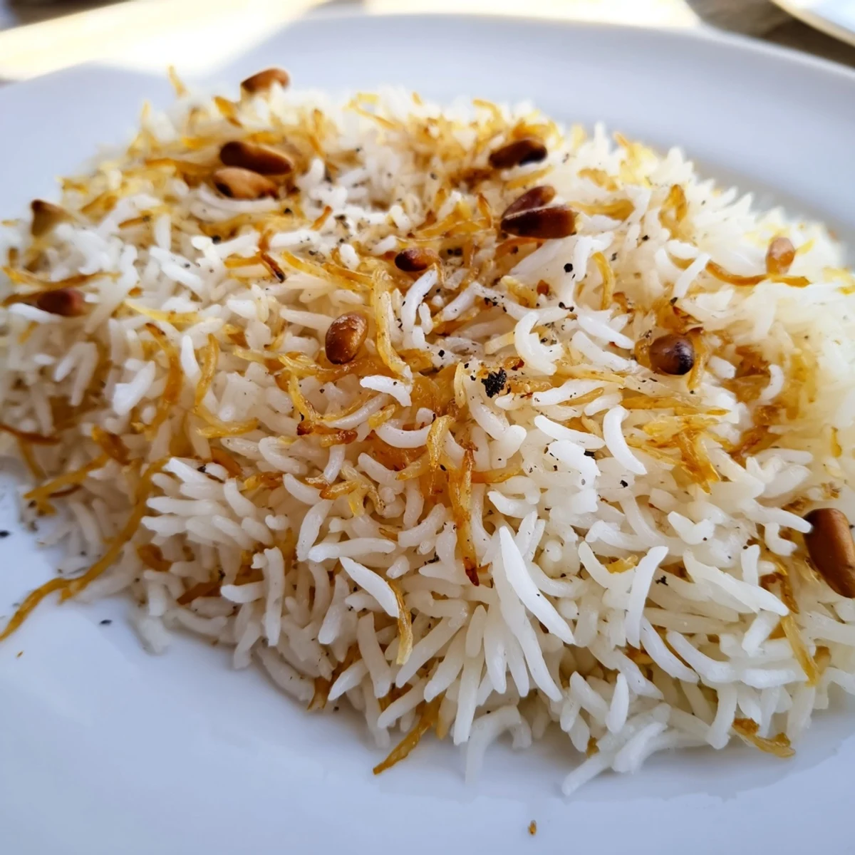 Aromatic Lebanese rice piled on a platter alongside grilled Middle Eastern vegetables