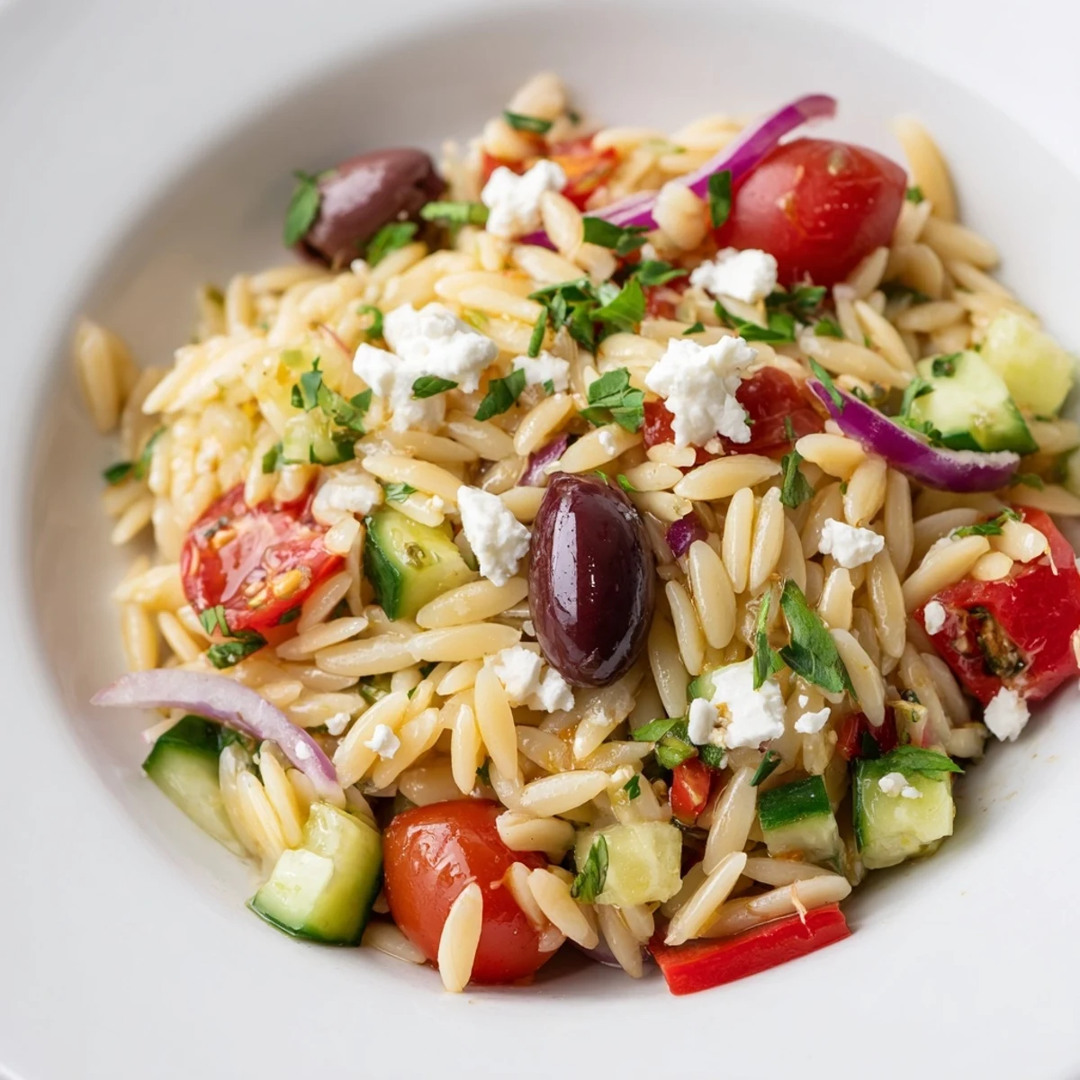 A vibrant Mediterranean Orzo Pasta Salad tossed with crisp veggies and zesty dressing
