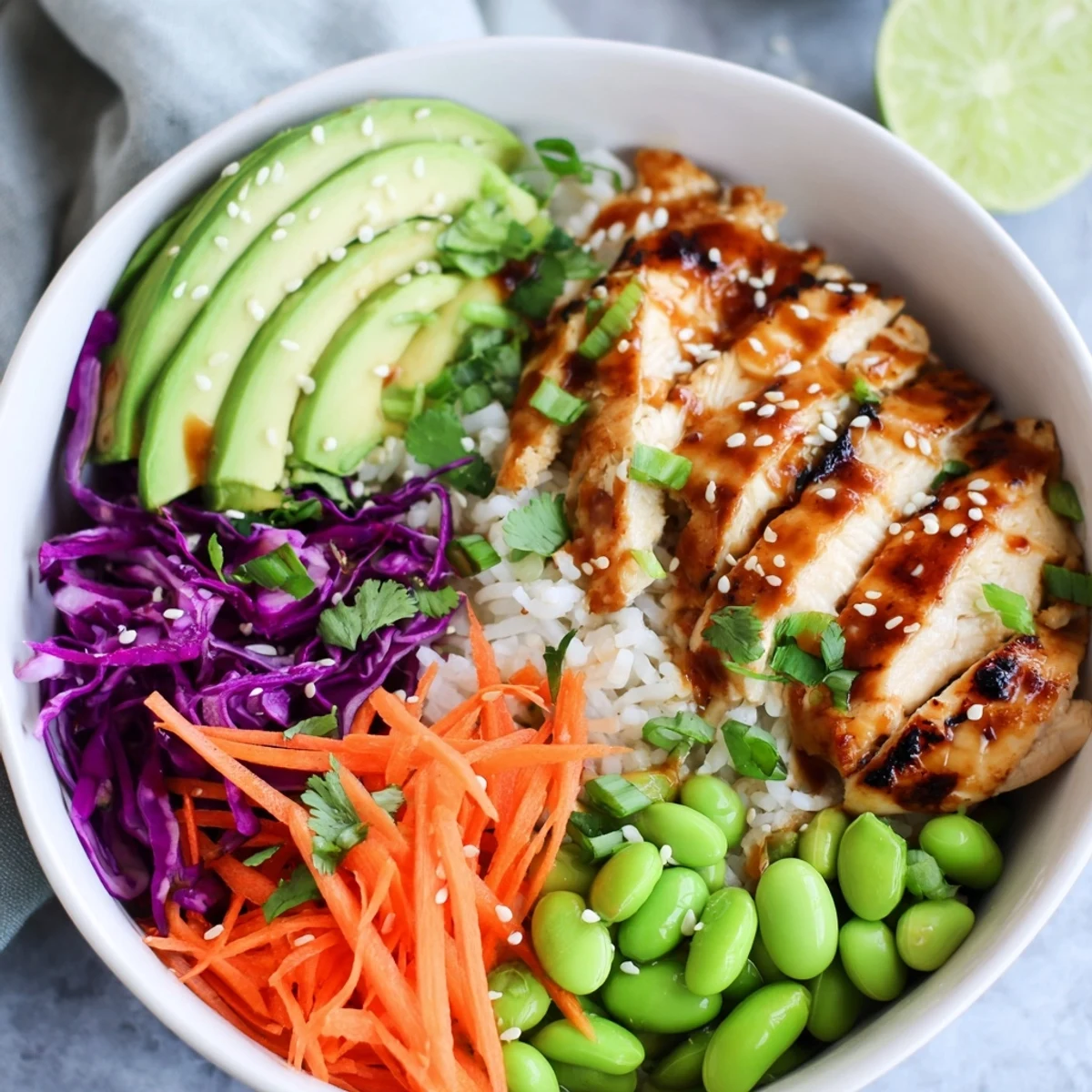 Colorful Asian Inspired Chicken Power Bowl layered over rice with avocado and edamame