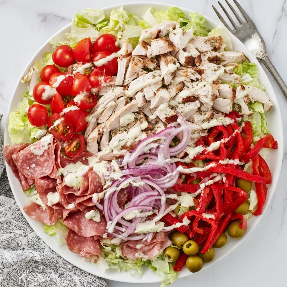 Sliced grilled chicken tops this hearty Italian grinder chicken salad with provolone, salami, and pepperoncini.