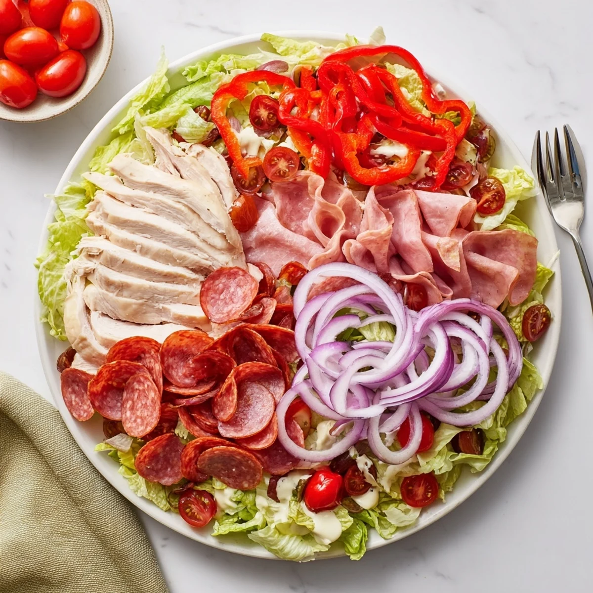 A colorful bowl of Italian grinder chicken salad loaded with savory meats and fresh veggies.