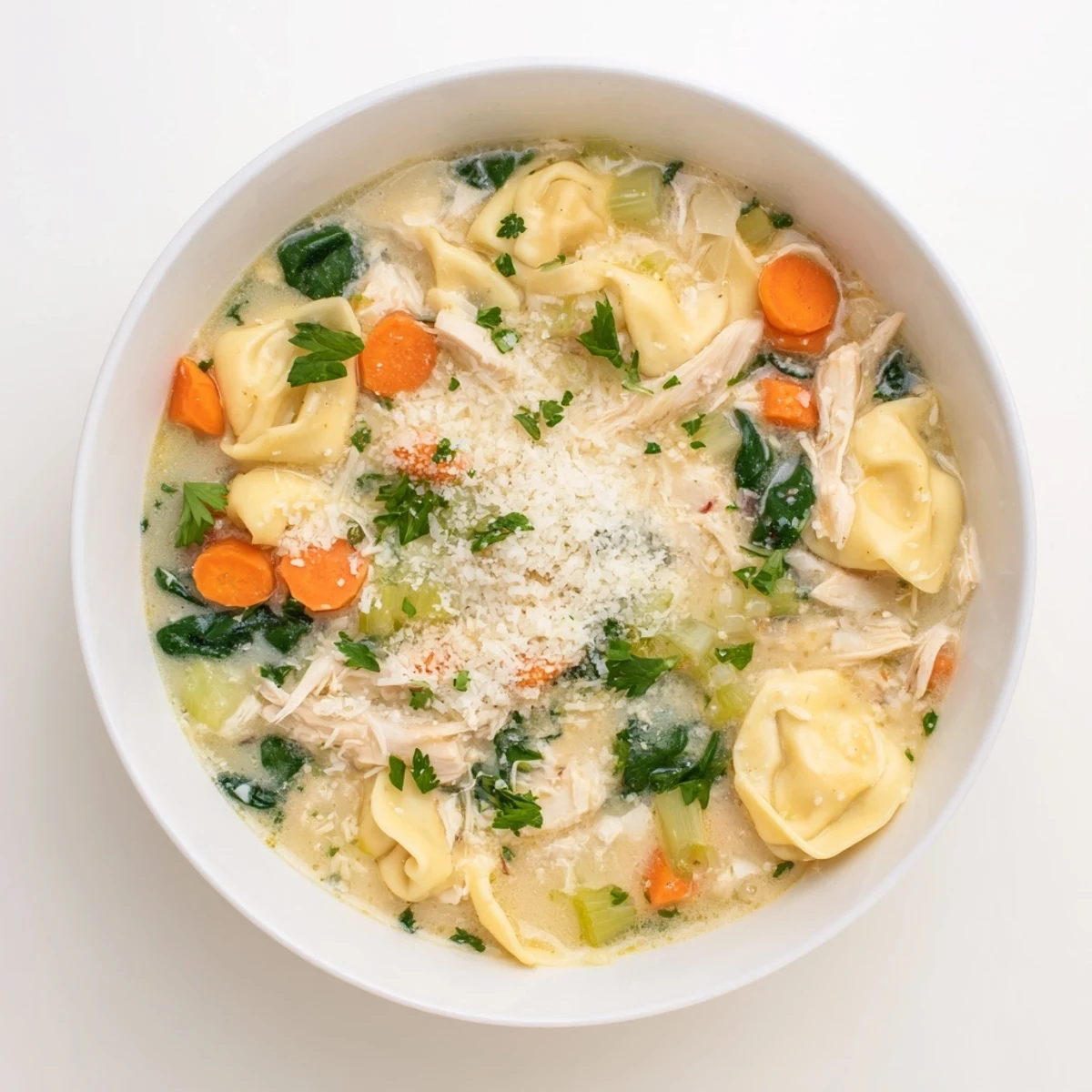Bubbling slow cooker Chicken Tortellini soup with tender spinach and cheese pasta in a rich broth.