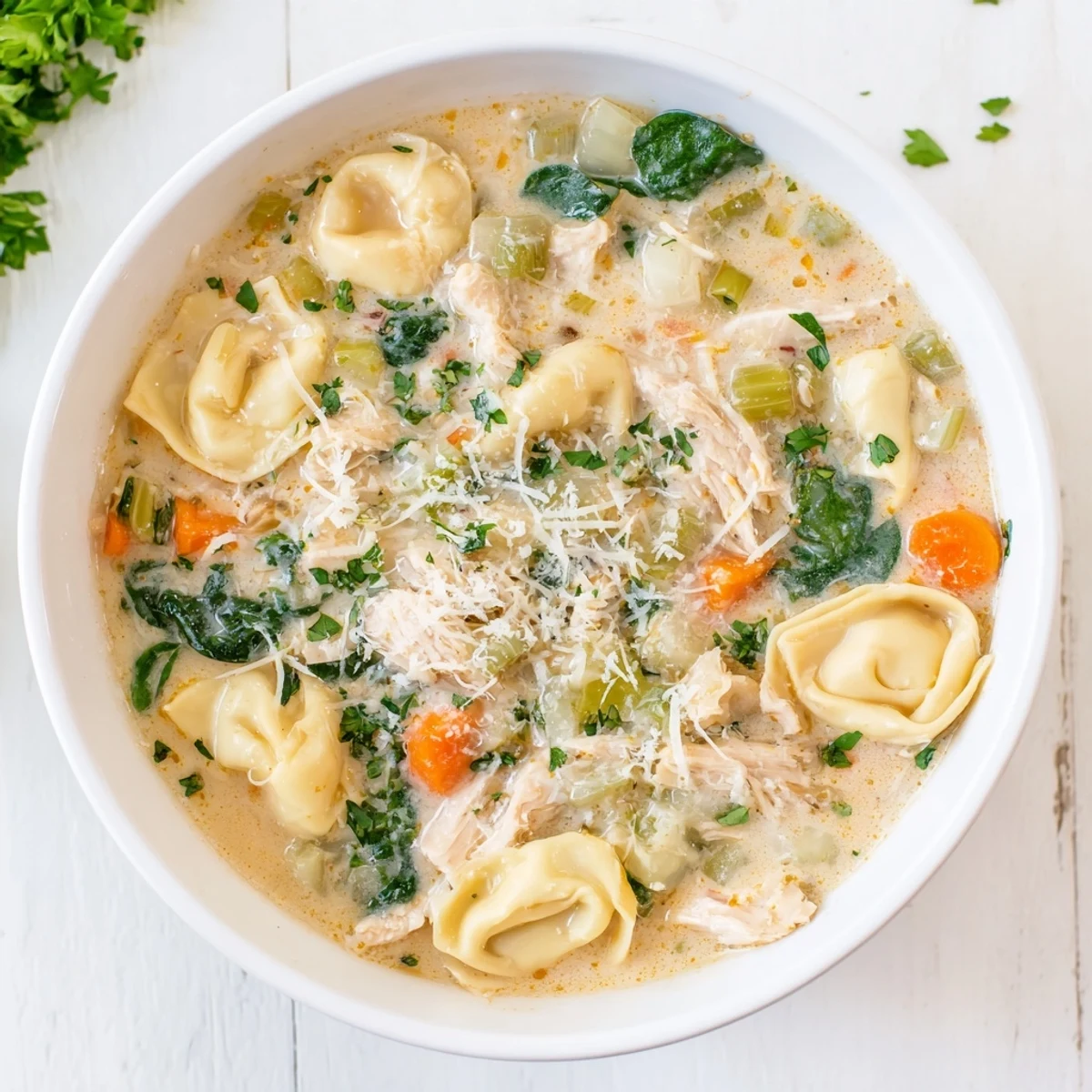 Savory Chicken Tortellini dish with shredded meat and fresh herbs served in a rustic crockpot.