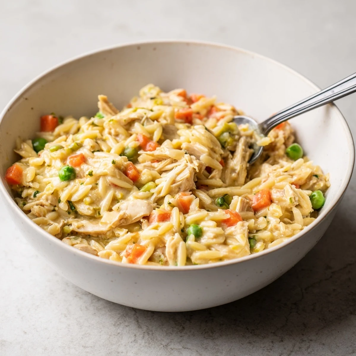One pot creamy chicken pot pie orzo simmered with peas and carrots in a savory white sauce.
